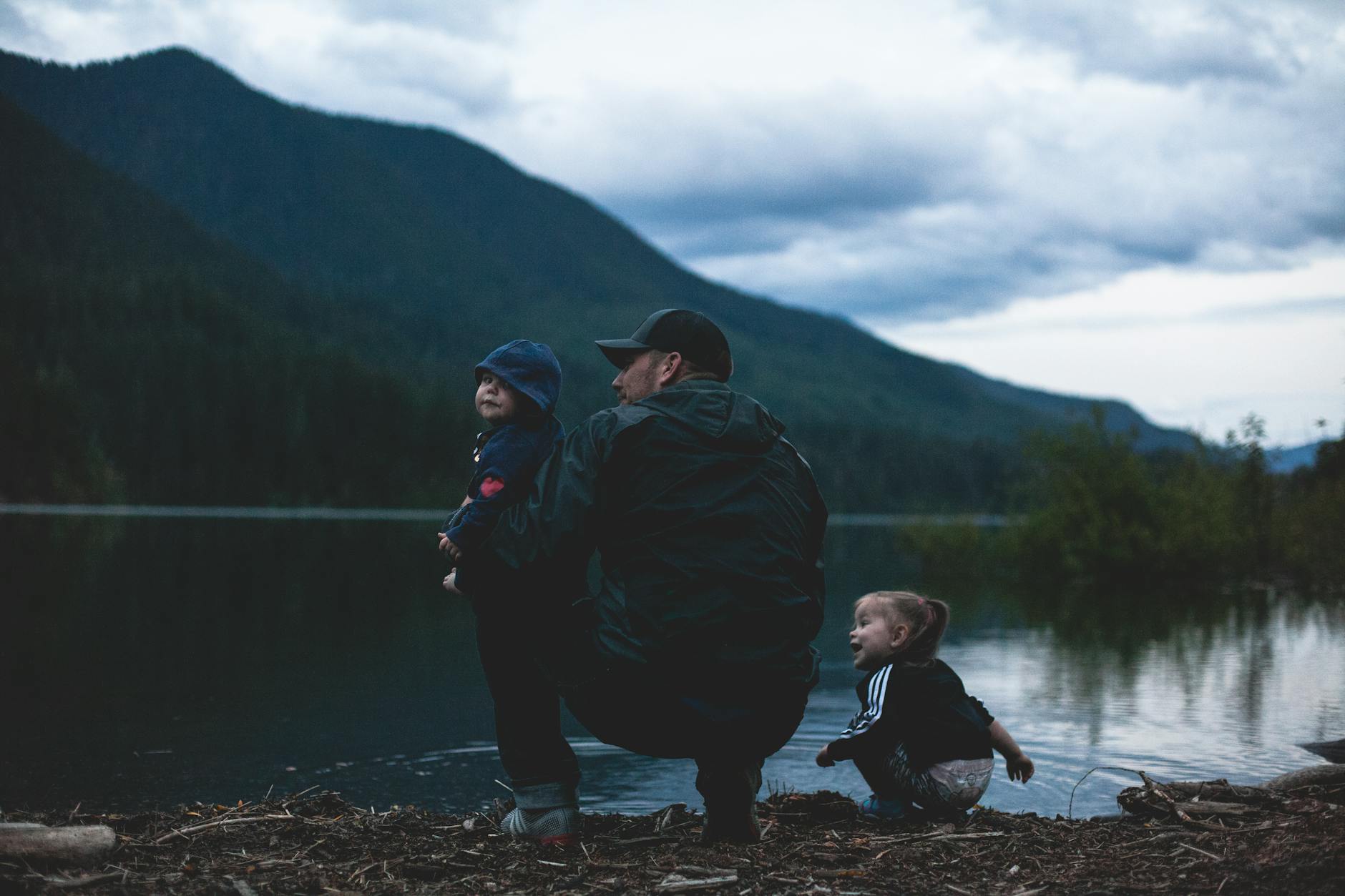 a father and his kids near body of water